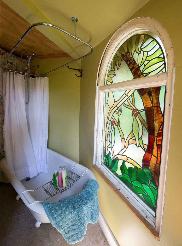 It’s a long story how a stained glass window ended up in a bathroom of this cottage. (Andy Bronson / The Herald)
