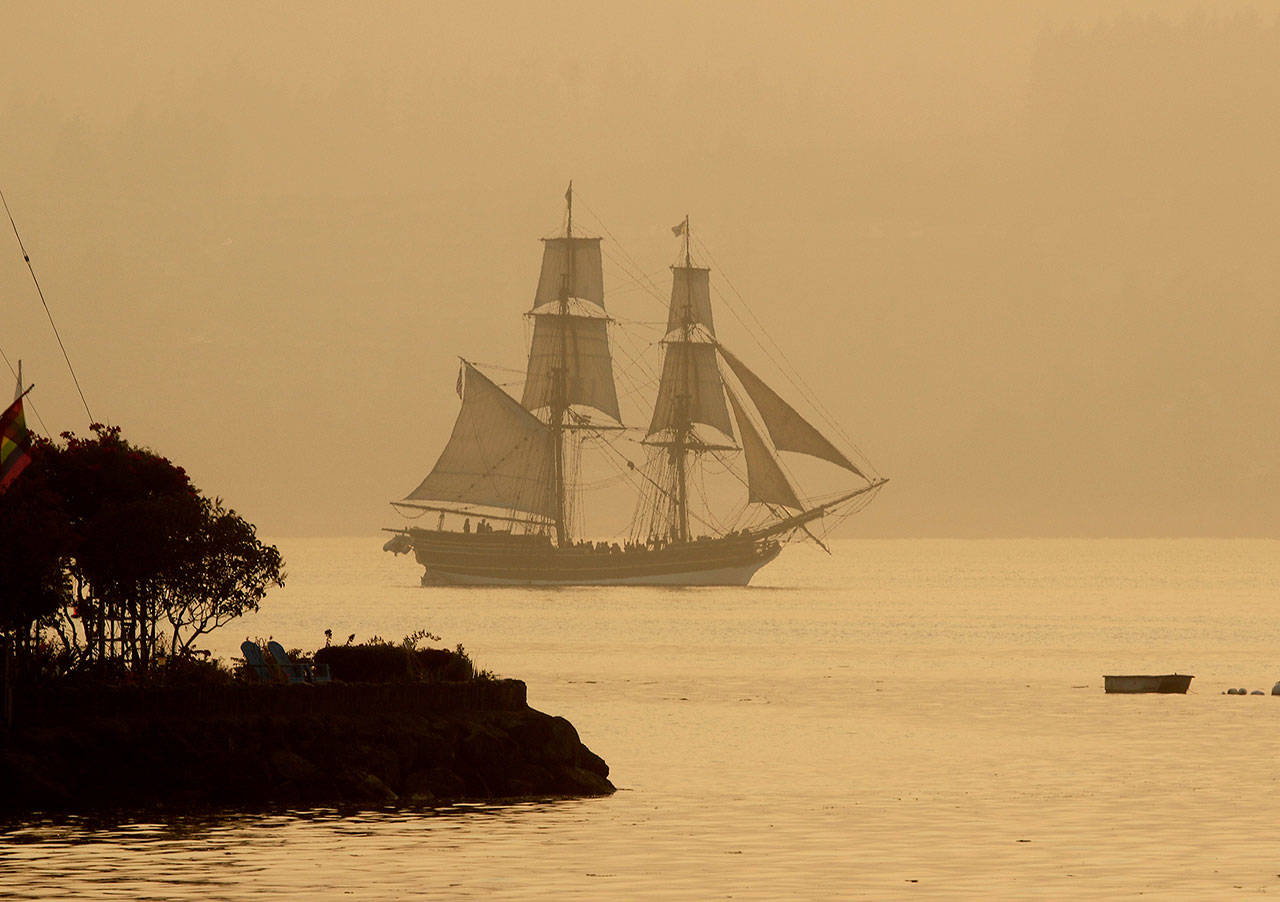 The tall ship Lady Washington sails off Port Orchard, in August 2018, through the smoky haze at sunset. The smoke was from the many wildfires in the Pacific Northwest and Canada. (Larry Steagall/Associated Press file photo)