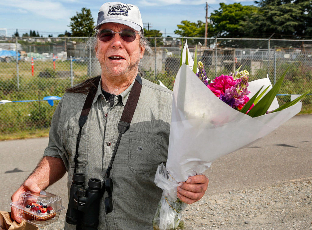 Jerry Miller, 66, carries his purchases from the Everett Farmers Market Sunday near Boxcar Park on the waterfront. He is unhappy about a new $2 fee to park at the market on Sundays. (Dan Bates / The Herald)
