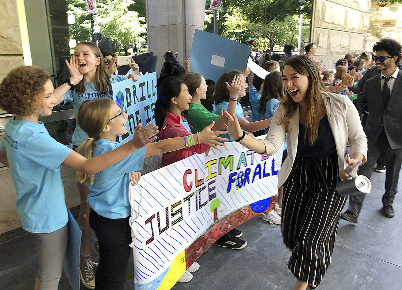 Kelsey Juliana, of Eugene, Oregon, a lead plaintiff who is part of a lawsuit by a group of young people who say U.S. energy policies are causing climate change and hurting their future, greets supporters outside a federal courthouse Tuesday, in Portland, Oregon. Three judges from the 9th U.S. Circuit Court of Appeals are hearing arguments from lawyers for 21 young people and the federal government in Portland but are not expected to rule right away. (AP Photo/Andrew Selsky)