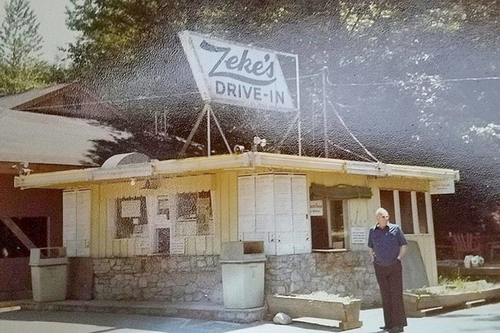 Earl “Zeke” Wells stands next to the original drive-in building in 1978. A grease fire in 1977 led to the construction of the current establishment. (Family photo)
