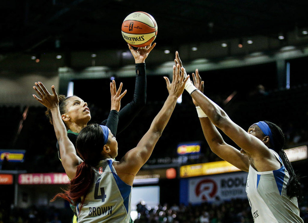 The Storm’s Alysha Clark shoots over two Lynx defenders. (Andy Bronson / The Herald)

