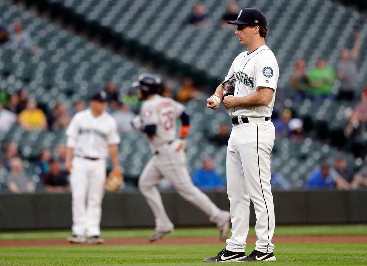 Mariners starting pitcher Andrew Moore (right) looks toward home as the Astros’ Robinson Chirinos runs the bases after a solo home run in the fourth inning of a game on June 4, 2019, in Seattle. (AP Photo/Elaine Thompson)