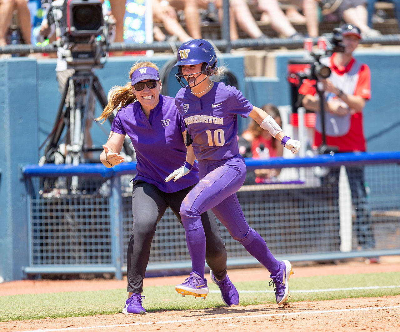 Washington freshman Sami Reynolds (10), a Snohomish High School alum, is congratulated by head coach Heather Tarr after hitting a home run during a Women’s College World Series game against Arizona on May 30 in Oklahoma City. (University of Washington)