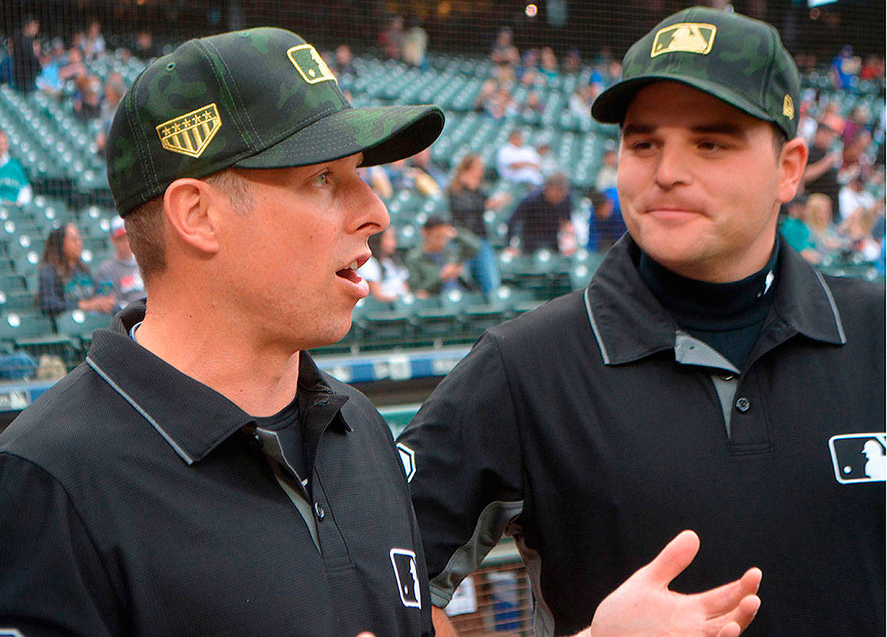 Tripp Gibson (left), of Marysville, talks with one of his fellow umpires prior to working a recent game between the Minnesota Twins and the Seattle Mariners at T-Mobile Park in Seattle.