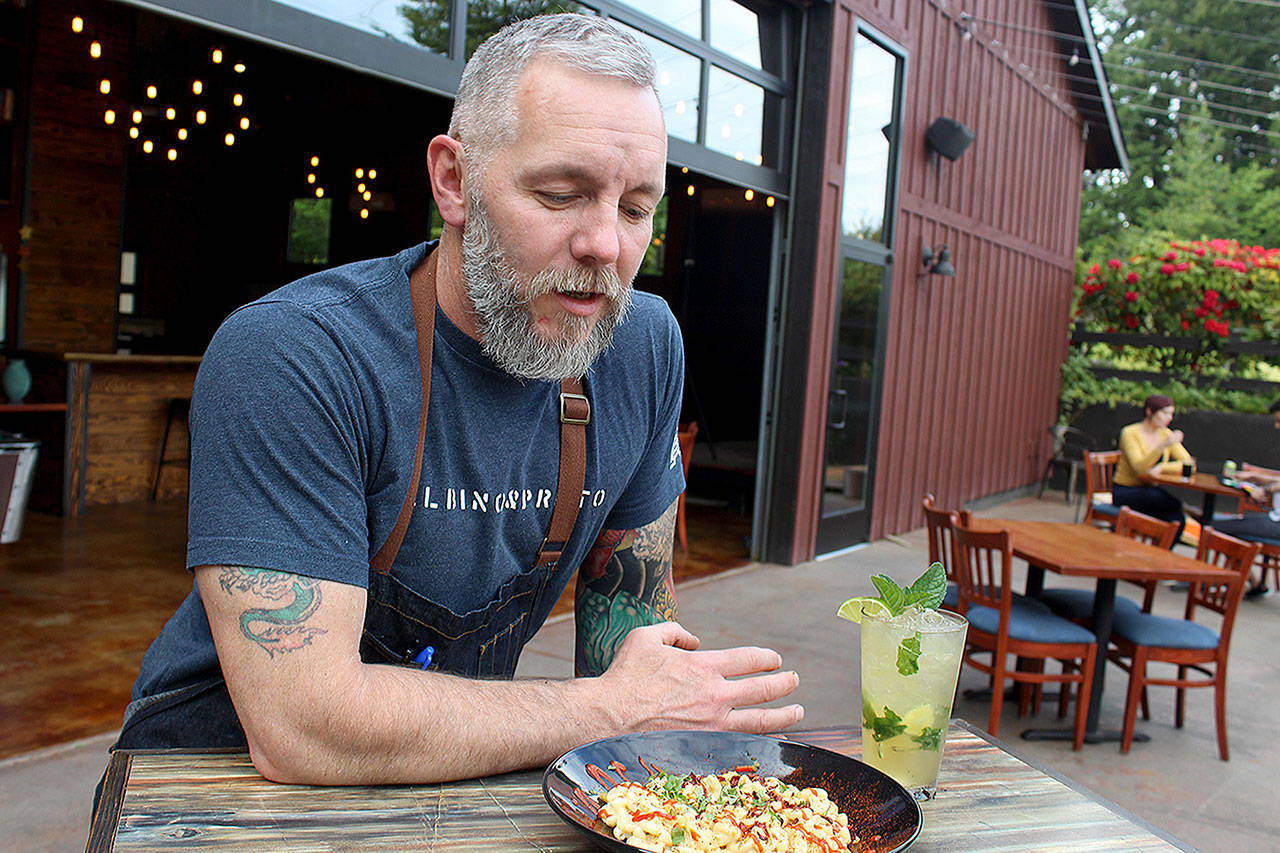 Owner J.P. Dowdell serves up a bowl of his favorite mac and cheese dish and a ginger mojito on the outside patio of Porter’s Public House in Langley. (Patricia Guthrie / Whidbey News Group)