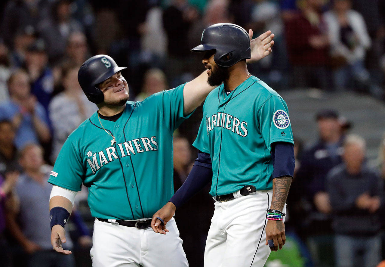 The Mariners’ Daniel Vogelbach (left) congratulates Domingo Santana on Santana’s two-run home run against the Astros during the sixth inning of a game on June 5, 2019, in Seattle. (AP Photo/Elaine Thompson)