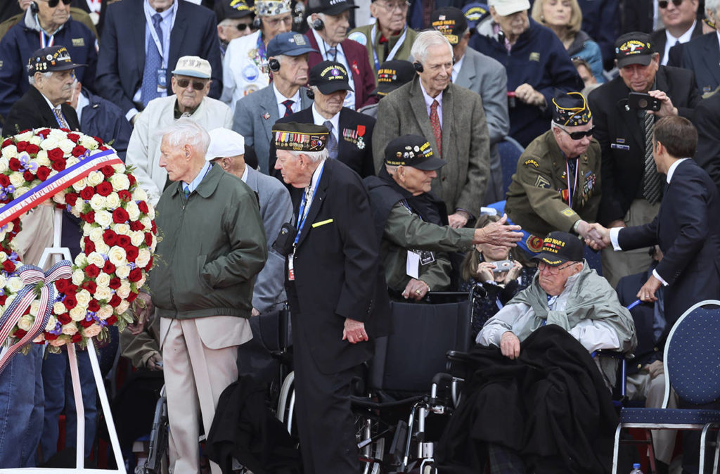 French President Emmanuel Macron (right) greets veterans during a ceremony to mark the 75th anniversary of D-Day at the Normandy American Cemetery in Colleville-sur-Mer, Normandy, France, on Thursday. World leaders are gathered Thursday in France to mark the 75th anniversary of the D-Day landings. (AP Photo/David Vincent)
