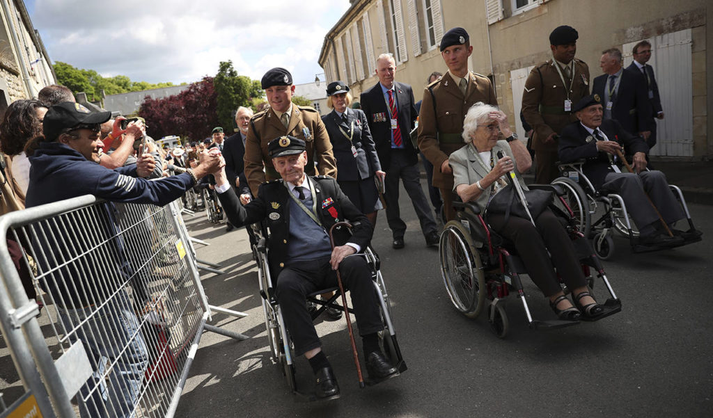 A spectator shakes the hand of a British veteran who is part of a procession leaving the Bayeux Cathedral after a ceremony to mark the 75th anniversary of D-Day in Bayeux, Normandy, France, on Thursday. The veterans will attend a service nearby at the Bayeux War Cemetery. (AP Photo/Francisco Seco)
