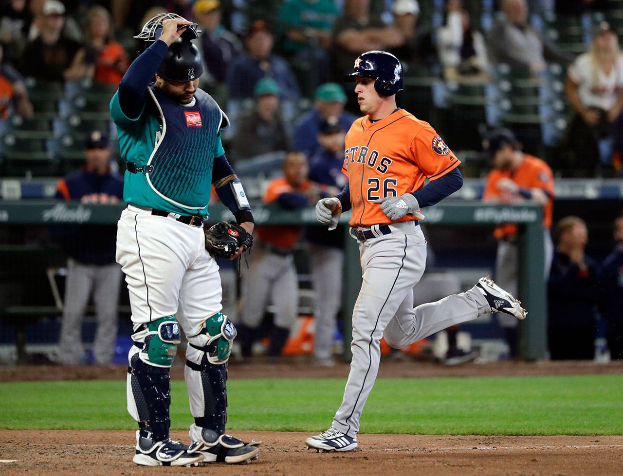 Mariners catcher Omar Narvaez (left) looks down as the Astros’ Myles Straw scores during the 14th inning of a game on June 6, 2019, in Seattle. (AP Photo/Elaine Thompson)