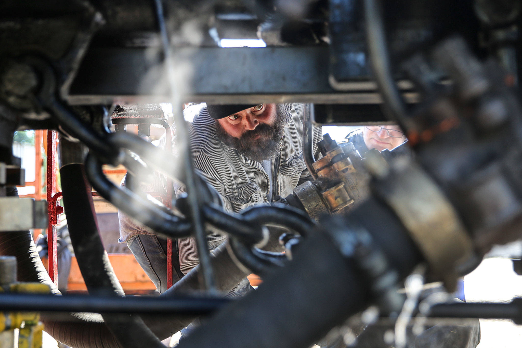 Jake Turner reviews some of the finishing touches on the restored 1947 steam engine at The Newell Corporation in Arlington on June 11. (Kevin Clark / The Herald)