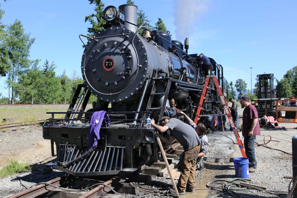 Crews put the finishing touches on the restored 1947 steam engine at The Newell Corporation in Arlington on June 11. (Kevin Clark / The Herald)
