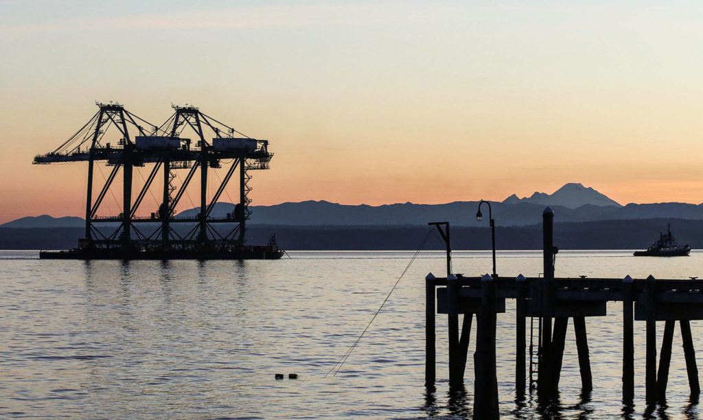 A pair of newly acquired port cranes make their way through Puget Sound off Mukilteo Tuesday after a 1,400-mile ocean journey from Los Angeles. (Kevin Clark / The Herald)
