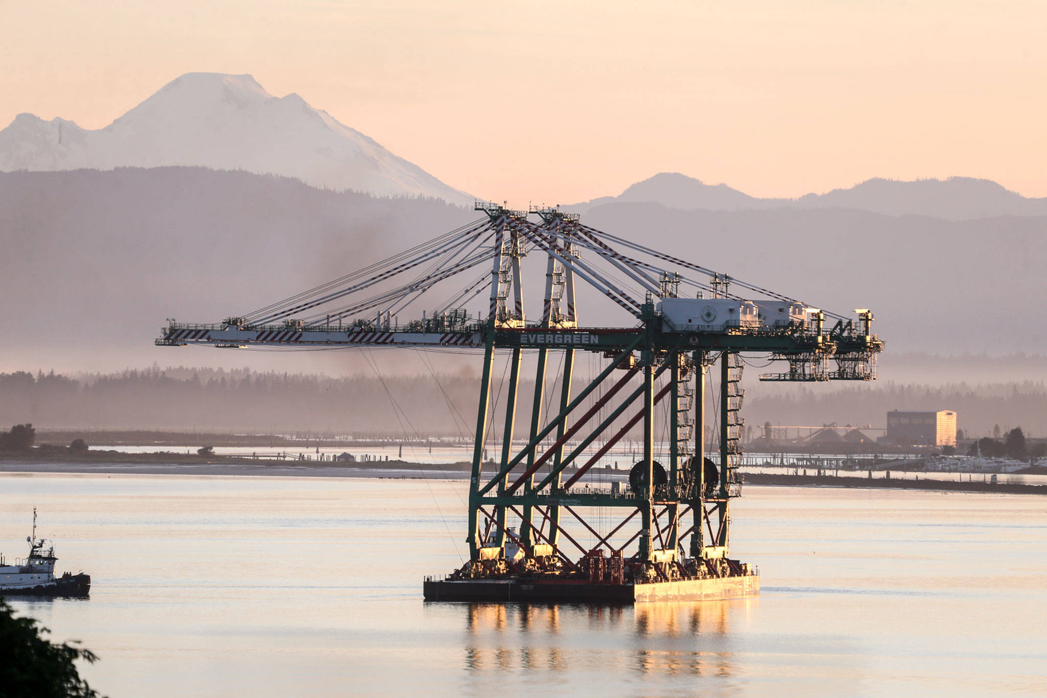 A pair of newly acquired port cranes make their way through Puget Sound off Mukilteo Tuesday after a 1,400-mile ocean journey from Los Angeles. (Kevin Clark / The Herald)