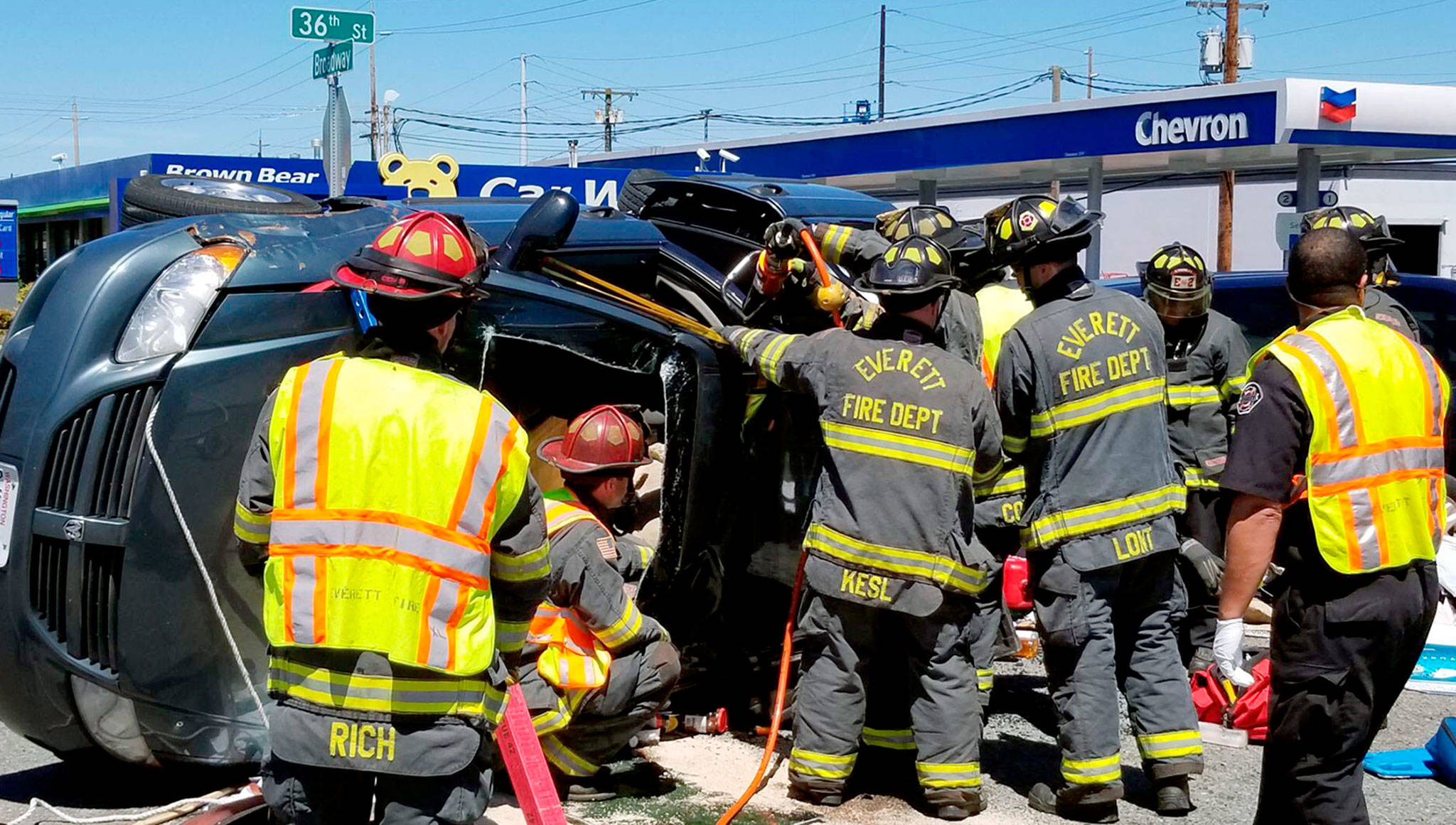 Firefighters work to extricate the driver of a car that rolled over Tuesday afternoon at the intersection of Broadway and 36th Street in Everett. (Everett Fire Department)