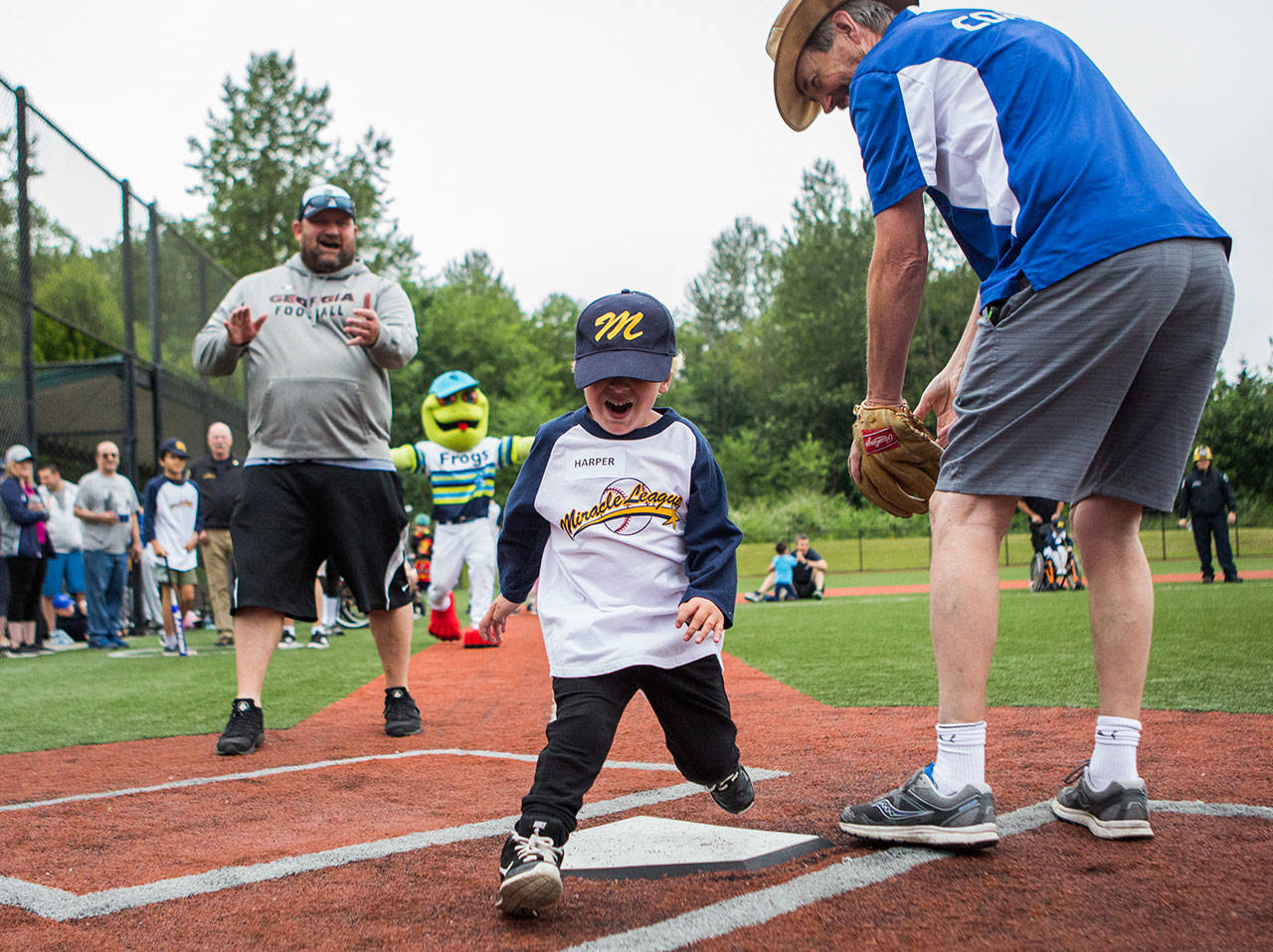 Harper Potter, 5, celebrates as he crosses home plate during the final Miracle League tripleheader of the season Saturday at Rotary Field in Monroe’s Skykomish River Park. The league was celebrating both its 20th season of existence and the 10-year anniversary of its own Rotary Field. (Olivia Vanni / The Herald)