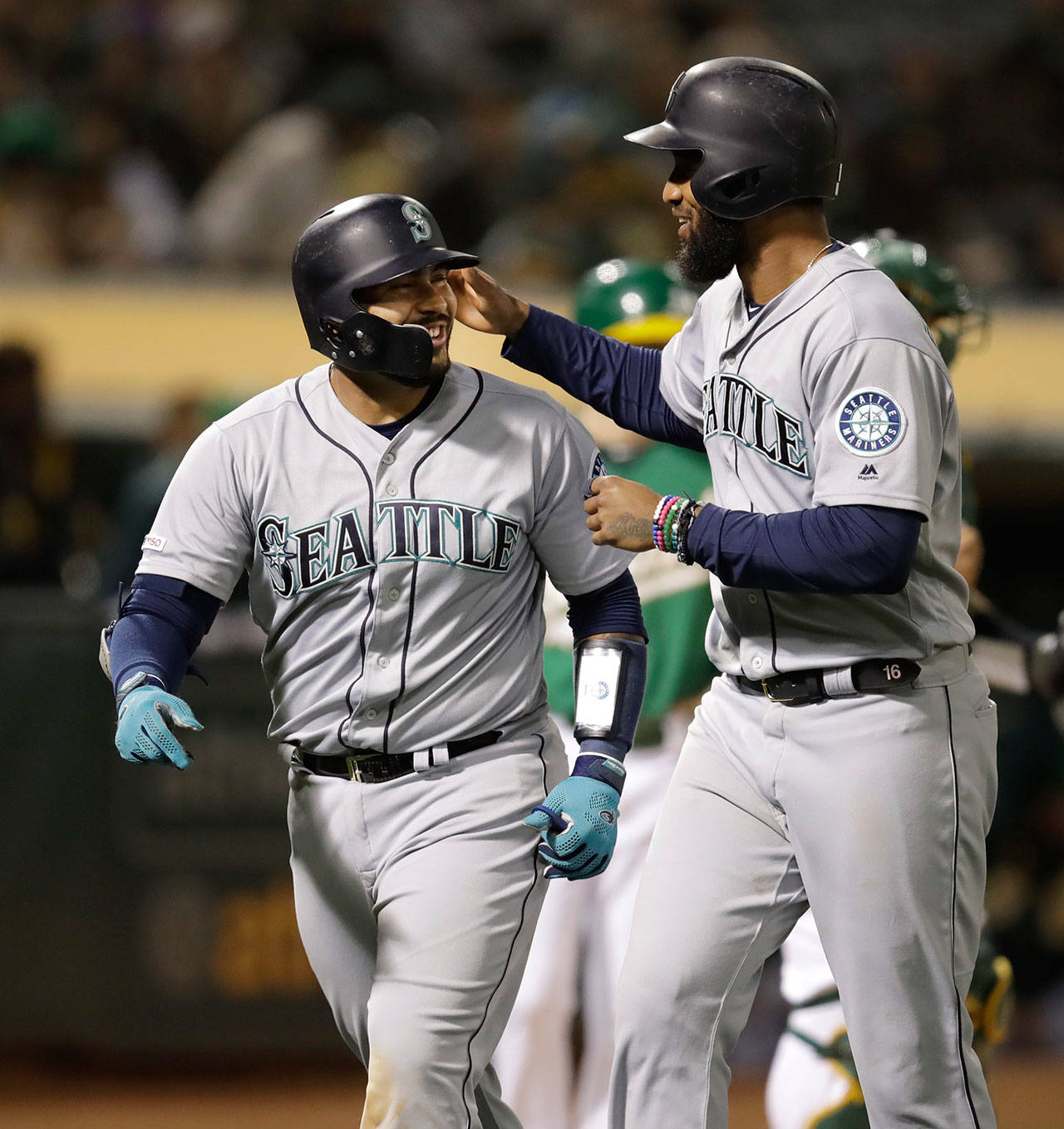 The Mariners’ Omar Narvaez (left) celebrates with Domingo Santana after hitting a two-run home run during the seventh inning of a game against the Athletics on June 14, 2019, in Oakland, Calif. (AP Photo/Ben Margot)