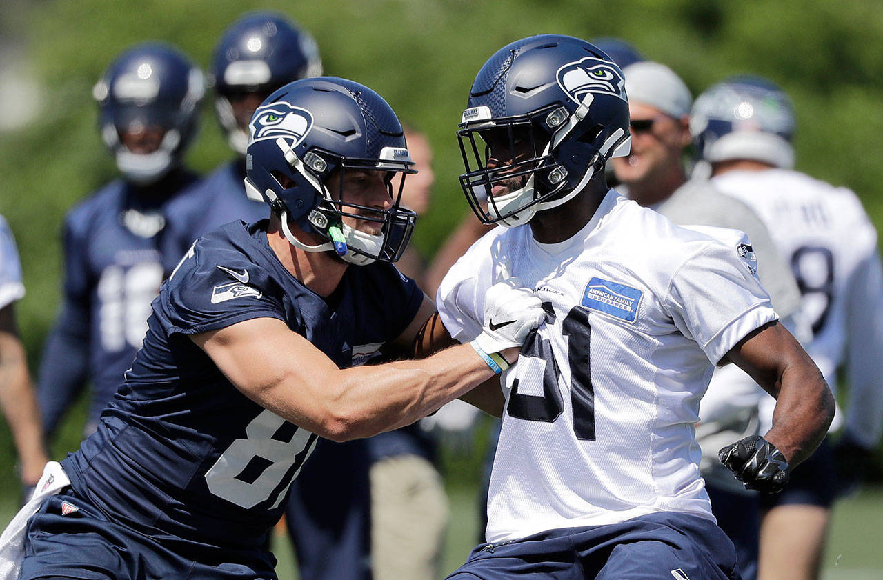 Seattle’s Nick Vannett (left) battles with Barkevious Mingo during the Seahawks’ offseason team activity Thursday at the team’s training facility in Renton. (AP Photo/Elaine Thompson)