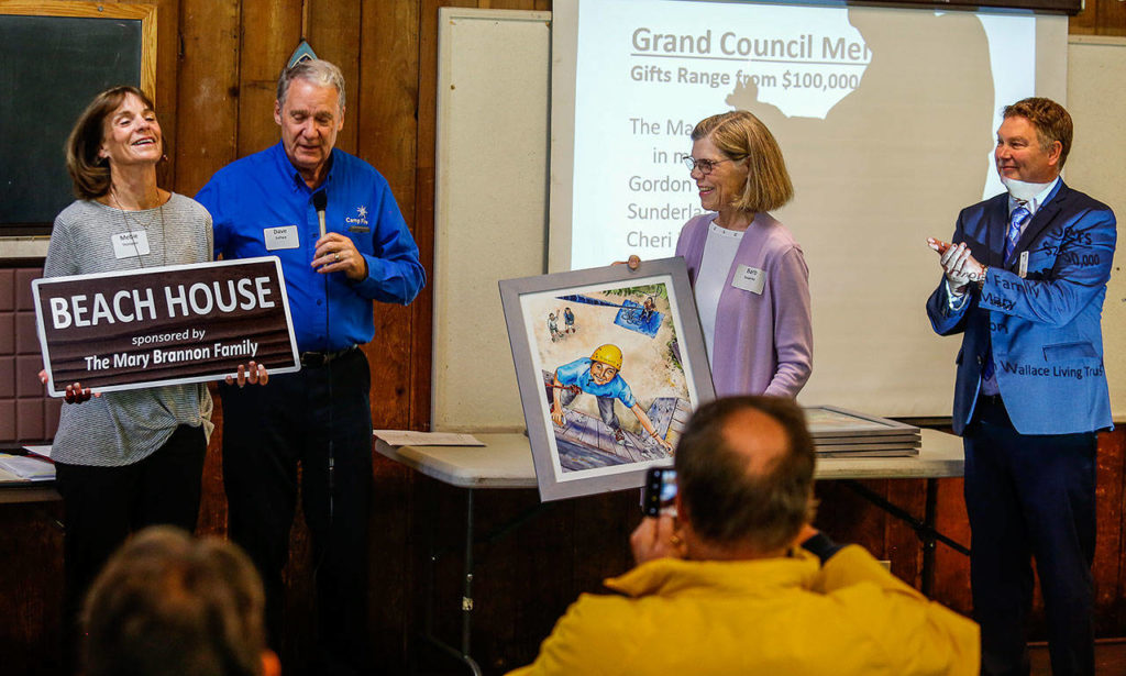Mebie Thompson (left) and her sister, Barbara Sweeney accept a sign in honor of their mother, Mary Brannon, who died in May at age 99. Brannon was described at the capital campaign event as the county’s oldest Camp Fire member. The sign will mark the beach house at Camp Killoqua.
