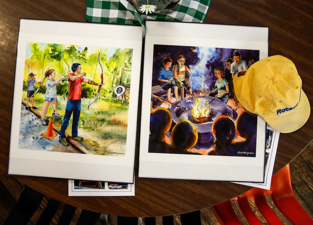 Framed prints of art work by Everett artist Elizabeth Person depicting Camp Killoqua scenes were given in appreciation Thursday to major donors. (Dan Bates / The Herald)
