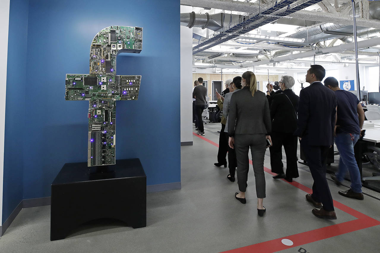 In this Jan. 9 photo, media and guests tour Facebook’s new 130,000-square-foot offices, which occupy the top three floors of a 10-story building in Cambridge, Massachusetts. Facebook unveiled a broad plan Tuesday, June 18, to create a new digital currency. (AP Photo/Elise Amendola, File)