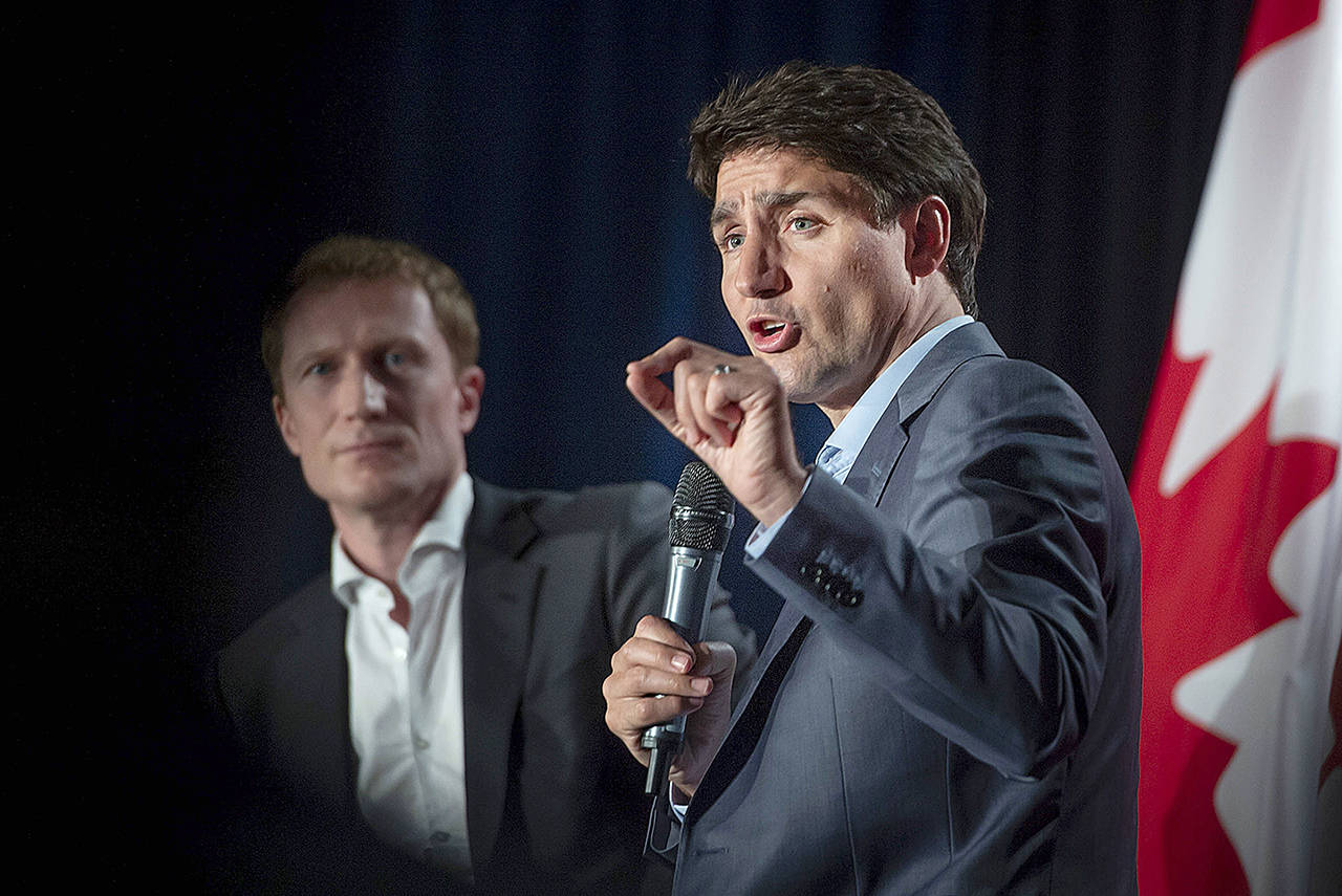 Canada Leader Justin Trudeau speaks to supporters as Marc Miller, MP of Ville-Marie-Le Sud-Ouest-Ile-des-Soeurs, looks on during an armchair discussion at an open Liberal Party fundraising event in Montreal, Quebec, on Monday. (Peter McCabe/The Canadian Press via AP)