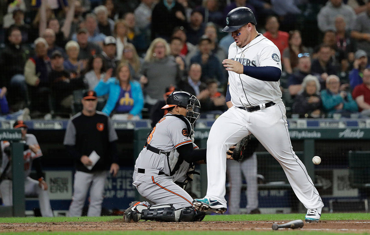 The Mariners’ Daniel Vogelbach (right) scores past Orioles catcher Pedro Severino during the sixth inning of a game on June 20, 2019, in Seattle. (AP Photo/Ted S. Warren)