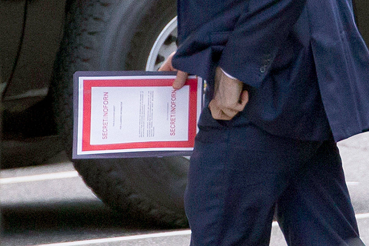 Outgoing acting Defense Secretary Patrick Shanahan carries a document labeled “secret” as he arrives for a meeting with President Donald Trump about Iran at the White House on Thursday in Washington. (AP Photo/Alex Brandon)
