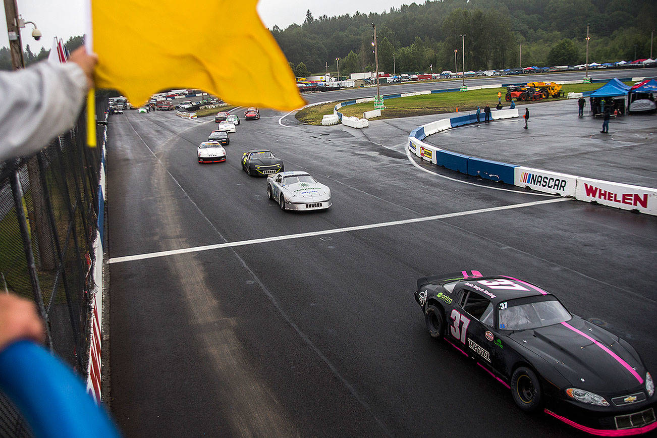 A race flagger signals the drivers before the start of the Street Stocks race during the Summer Showdown at the Evergreen Speedway on Saturday, June 30, 2018 in Monroe, Wa. (Olivia Vanni / The Herald)