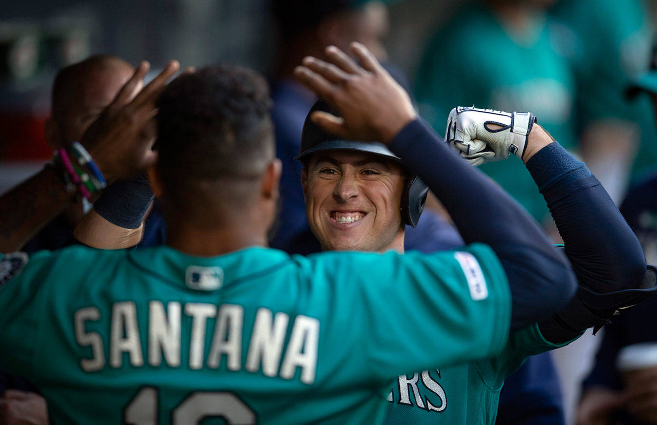 The Mariners’ Dylan Moore (right) celebrates with teammate Domingo Santana after hitting a solo home run during the second inning of a game against the Oriokes on June 21, 2019, in Seattle. (AP Photo/Stephen Brashear)