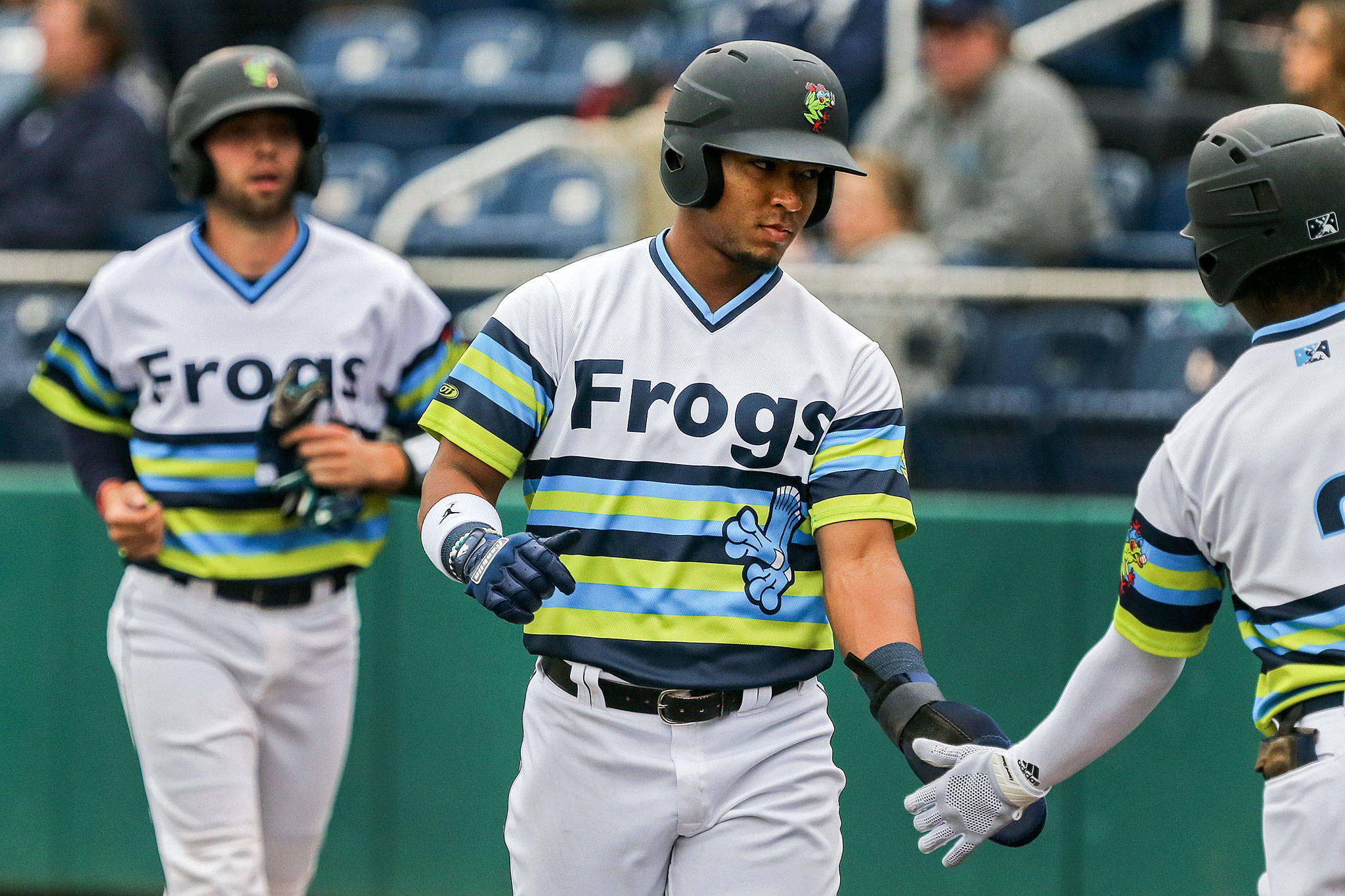 Everetts Robert Perez Jr. (center), followed by Carter Bins, is congratulated by teammate Luis Joseph after scoring a run Sunday at Funko Field. (Kevin Clark / The Herald)
