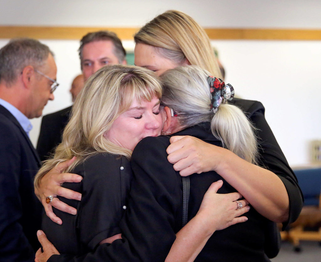 May Robson (left-right) Kelly Cook and Lee Cook share a hug after William Talbott II is found guilty of all charges Friday morning at the Snohomish County Court House in Everett on June 28, 2019. (Kevin Clark / The Herald)
