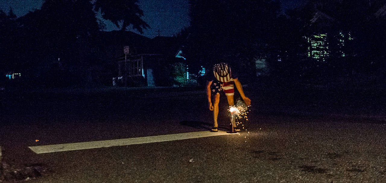 In this 2018 photo, Jeffery Kasch lights fireworks in Everett. Fire officials are hoping to outlaw personal fireworks on the outskirts of Everett, Lynnwood and Edmonds. (Olivia Vanni / Herald file)