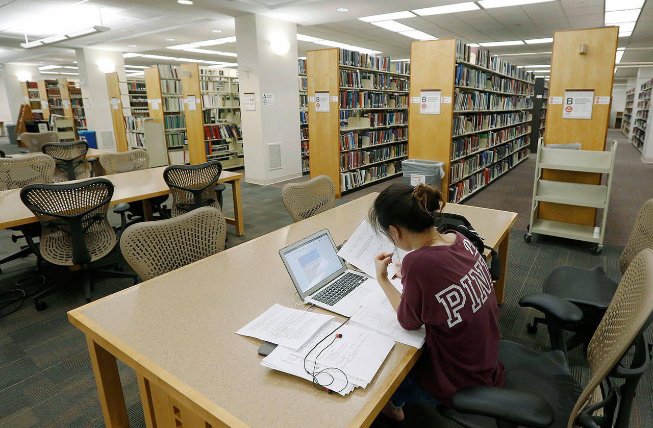 A student works in the library at Virginia Commonwealth University in Richmond on June 20. Those who graduate college with student loans owe close to $30,000 on average, according to the most recent data from the Institute for College Access & Success. (AP Photo/Steve Helber)