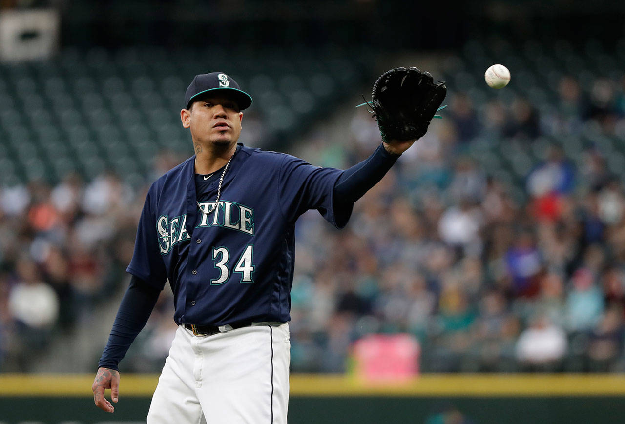 Mariners starting pitcher Felix Hernandez reaches for a ball against the Tigers in the first inning of a game May 18, 2018, in Seattle. (AP Photo/Elaine Thompson)