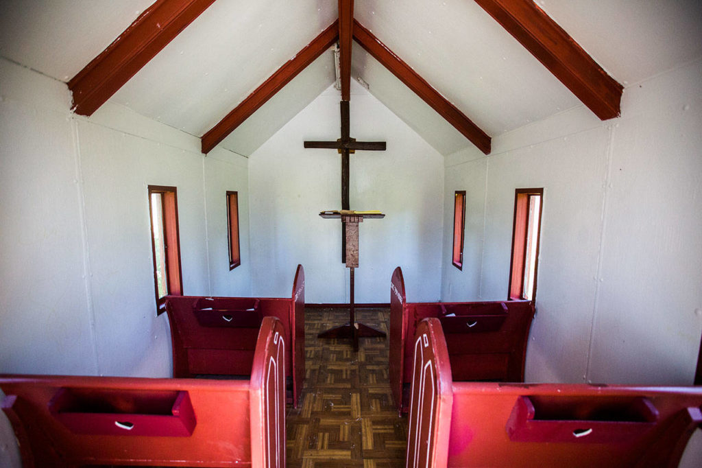 A white interior with four red pews at the Wayside Chapel on U.S. 2. (Olivia Vanni / The Herald)
