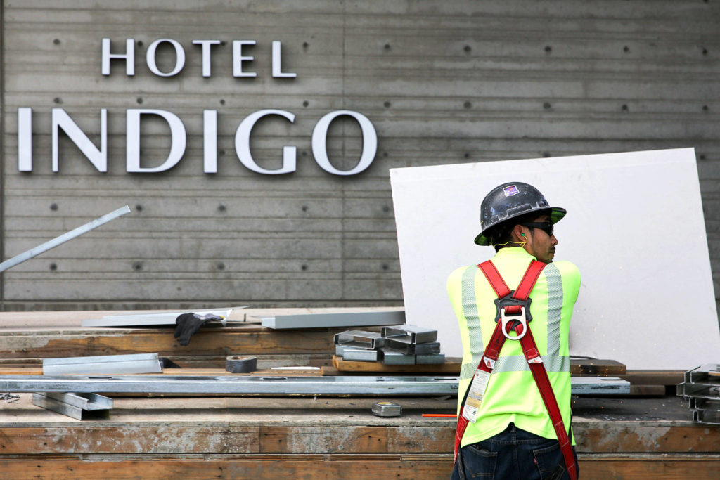 A construction worker cuts steel at Hotel Indigo during construction at the Port of Everett’s Waterfront Place last month. (Kevin Clark / The Herald) 
