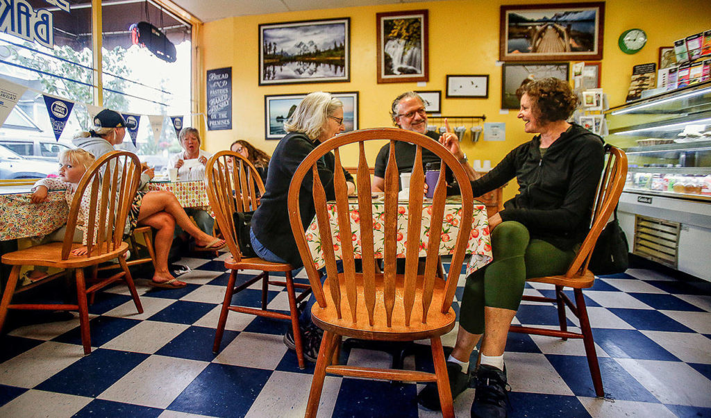 Eileen Hambleton (right) and Jeff Shober talk with another customer at Sky River Bakery on Tuesday. “I’m a regular, “Hambleton said “but I’m trying to cut back.” (Dan Bates / The Herald)
