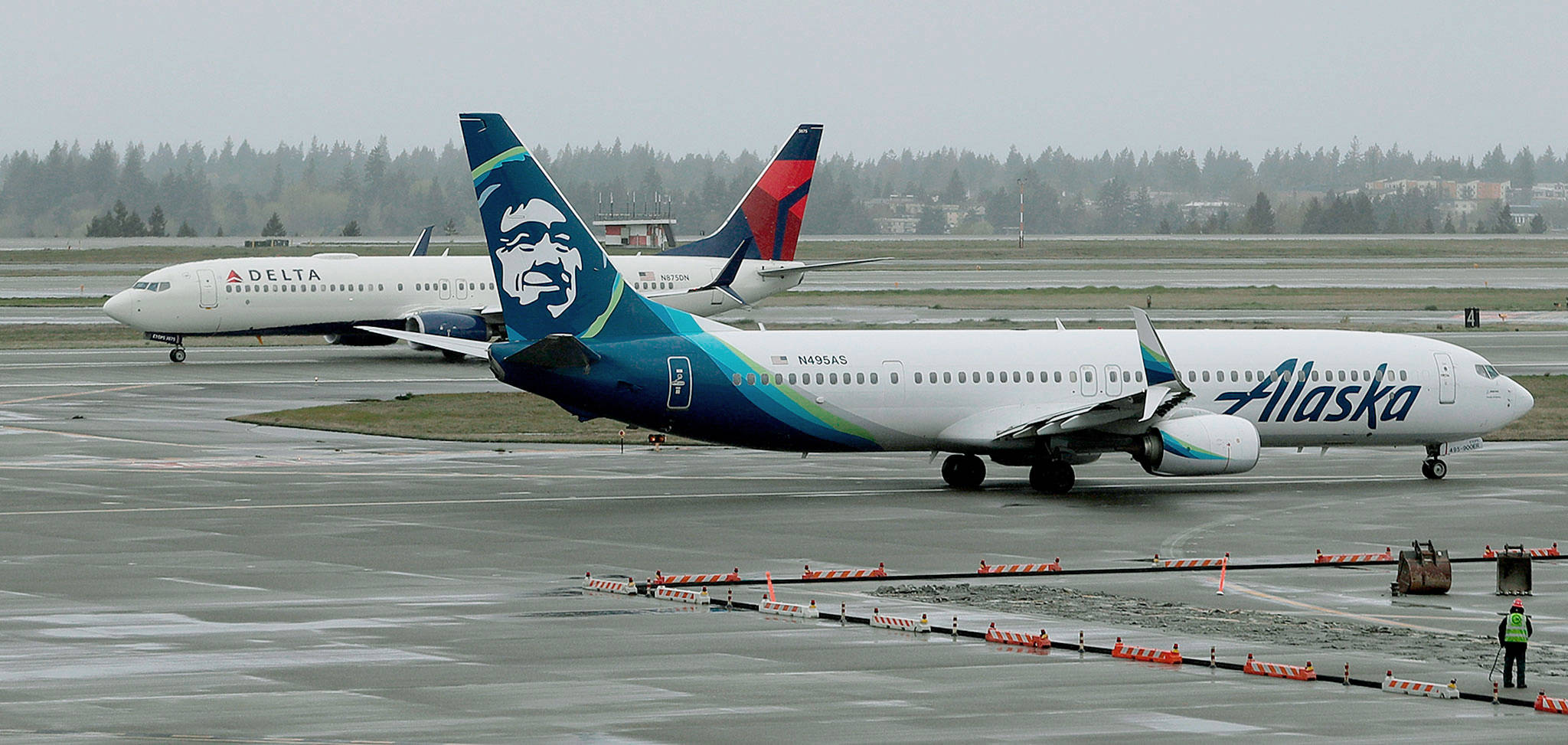A Delta Air Lines Boeing 737 taxis behind a Alaska Airlines 737 at Seattle-Tacoma International Airport. (AP Photo/Ted S. Warren)