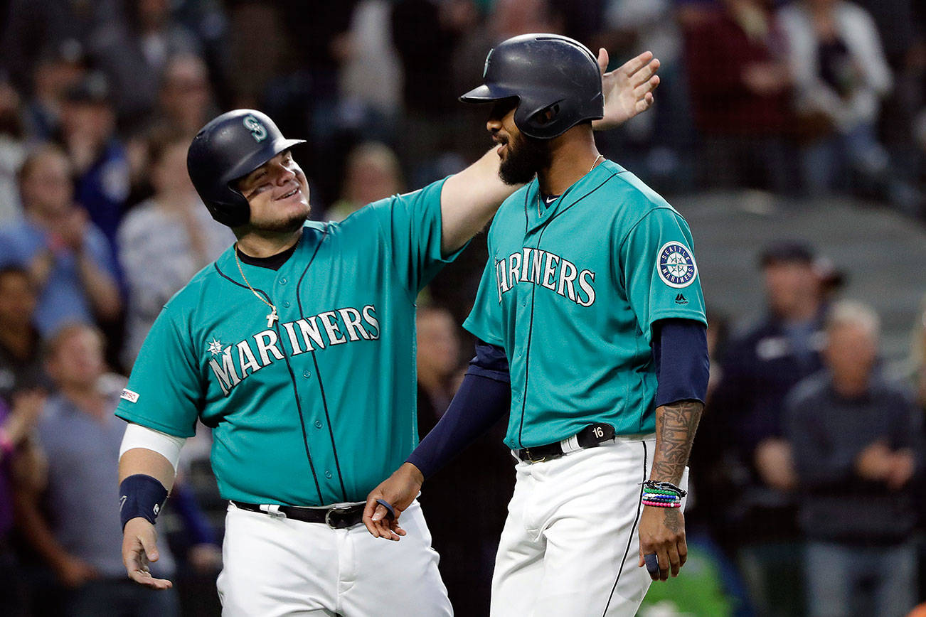 The Seattle Mariners’ Daniel Vogelbach, left, congratulates Domingo Santana on Santana’s two-run home run against the Houston Astros during the sixth inning of a baseball game Wednesday, June 5, 2019, in Seattle. (AP Photo/Elaine Thompson)