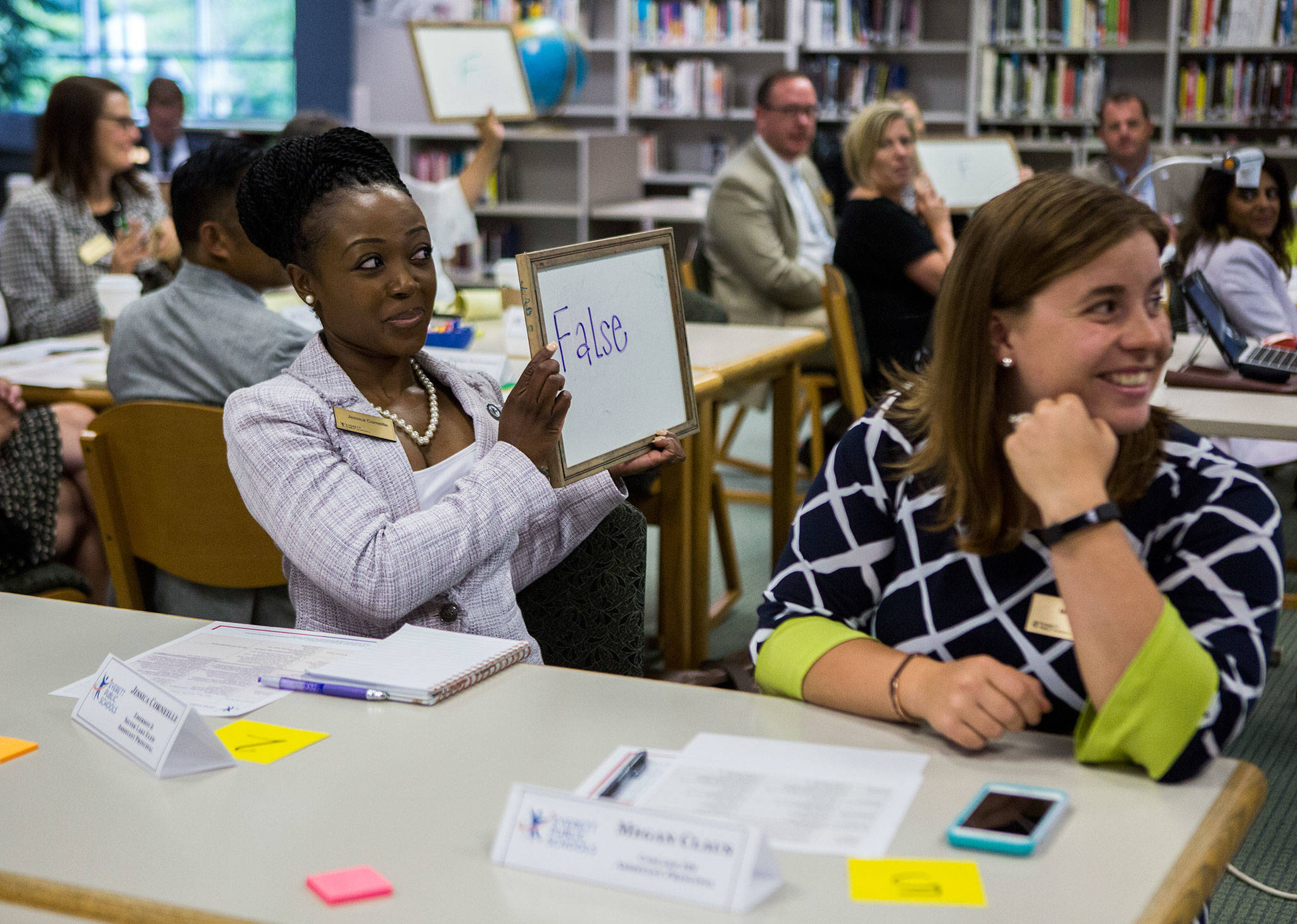 Emerson and Silver Lake Elementary assistant principal Jessica Corneille holds up a white board with her team’s answer during a true or false game during one of the school stops for the Everett Public School’s administration induction at Henry M. Jackson High School on July 2 in Everett. (Olivia Vanni / The Herald)