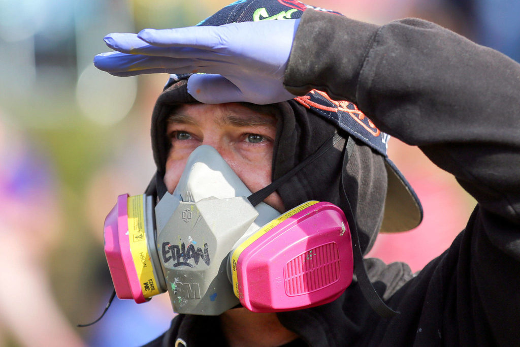 Ethan Patchell of San Francisco gauges his work on the mural the afternoon of July 4. (Kevin Clark / The Herald)
