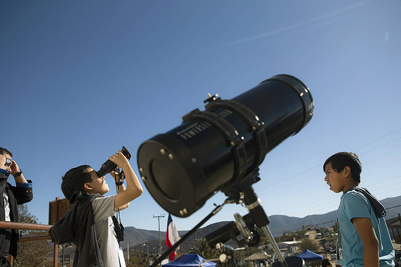 Children test out special binoculars to view the total solar eclipse near Central Park in La Higuera, Chile, on July 1. (AP Photo/Esteban Felix)