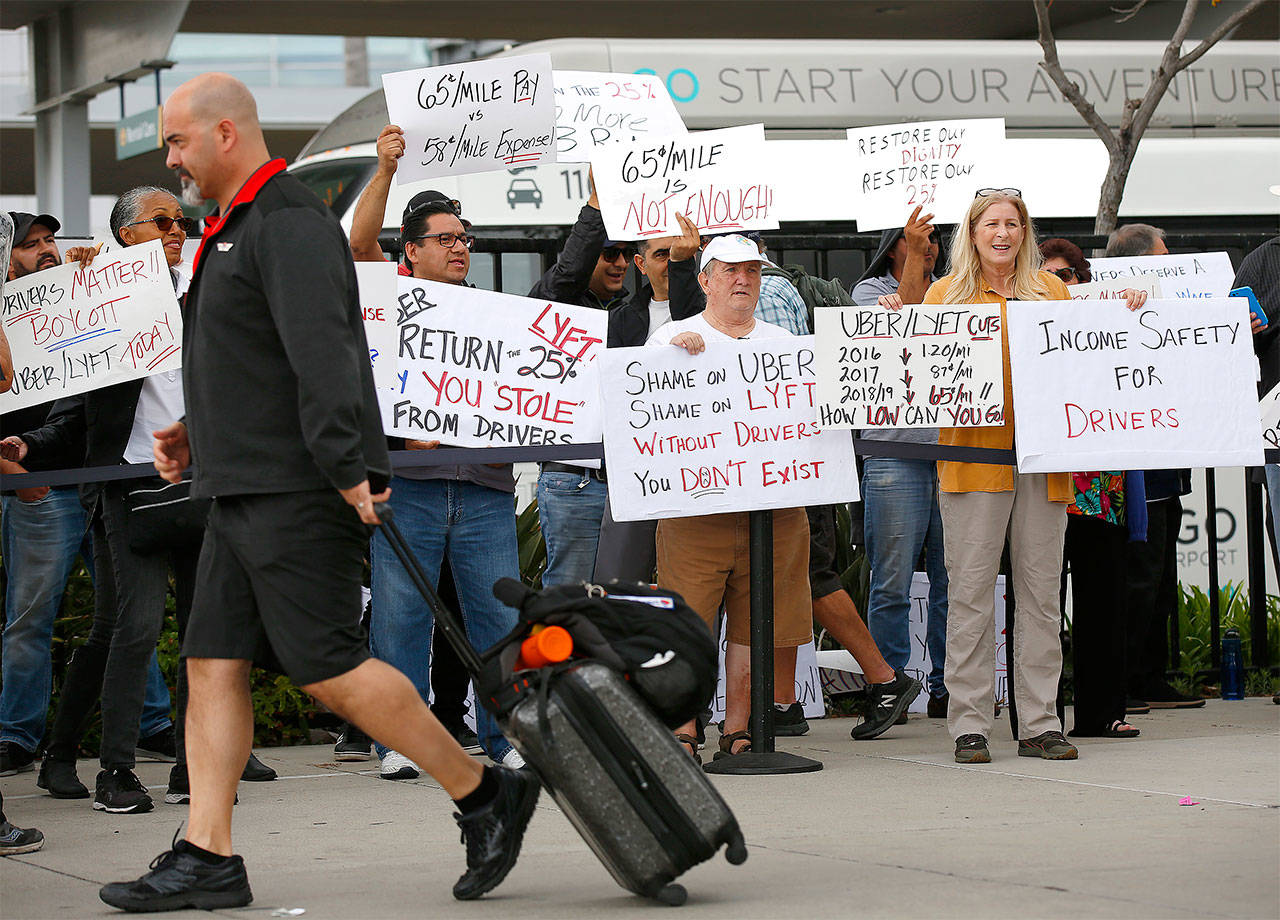 Uber and Lyft drivers picket at San Diego International Airport during a 24-hour strike in an effort to demand better pay and treatment from the tech giants on May 7. (K.C. Alfred / The San Diego Union-Tribune)