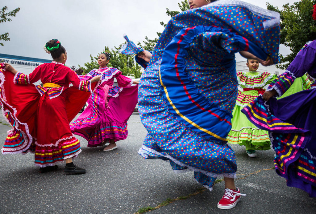 Baile Folklore Colibri members dance in the Everett High School parking lot before the start of the annual July Fourth parade. (Olivia Vanni / The Herald)
