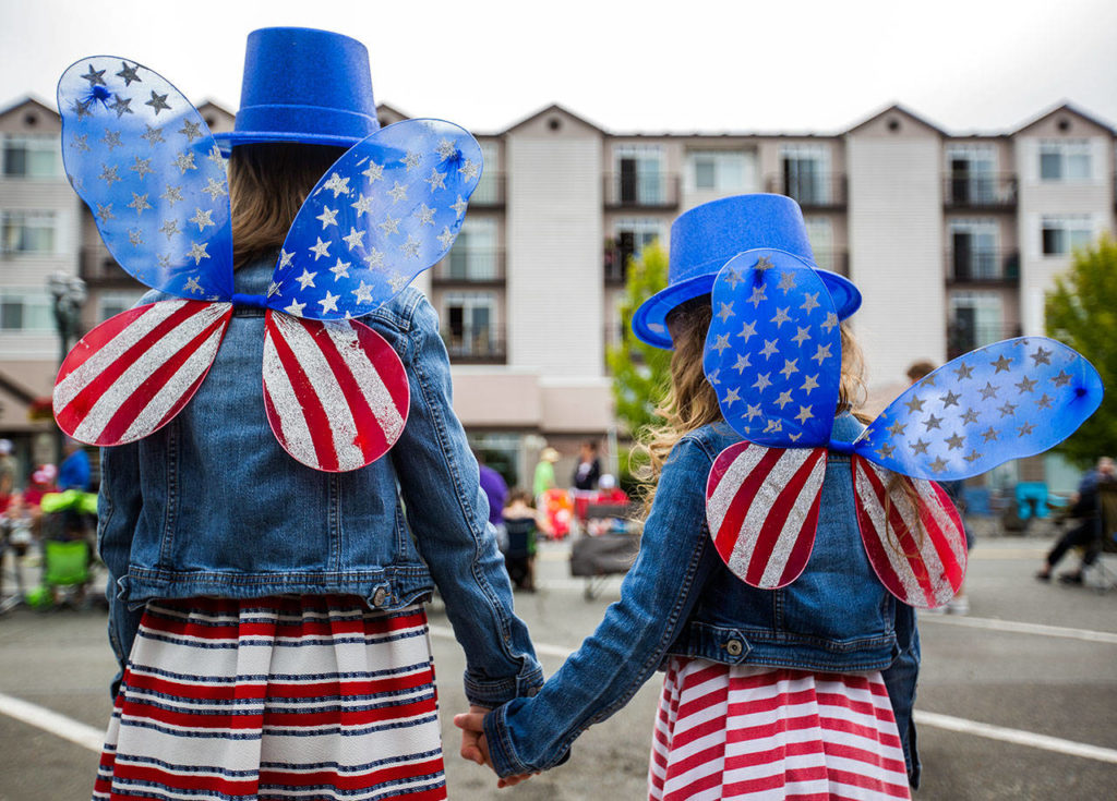 Audri Acosta, 8, and Valentina Acosta, 4, pose for a picture of their watching American flag wings during Everett’s annual Fourth of July parade. (Olivia Vanni / The Herald)
