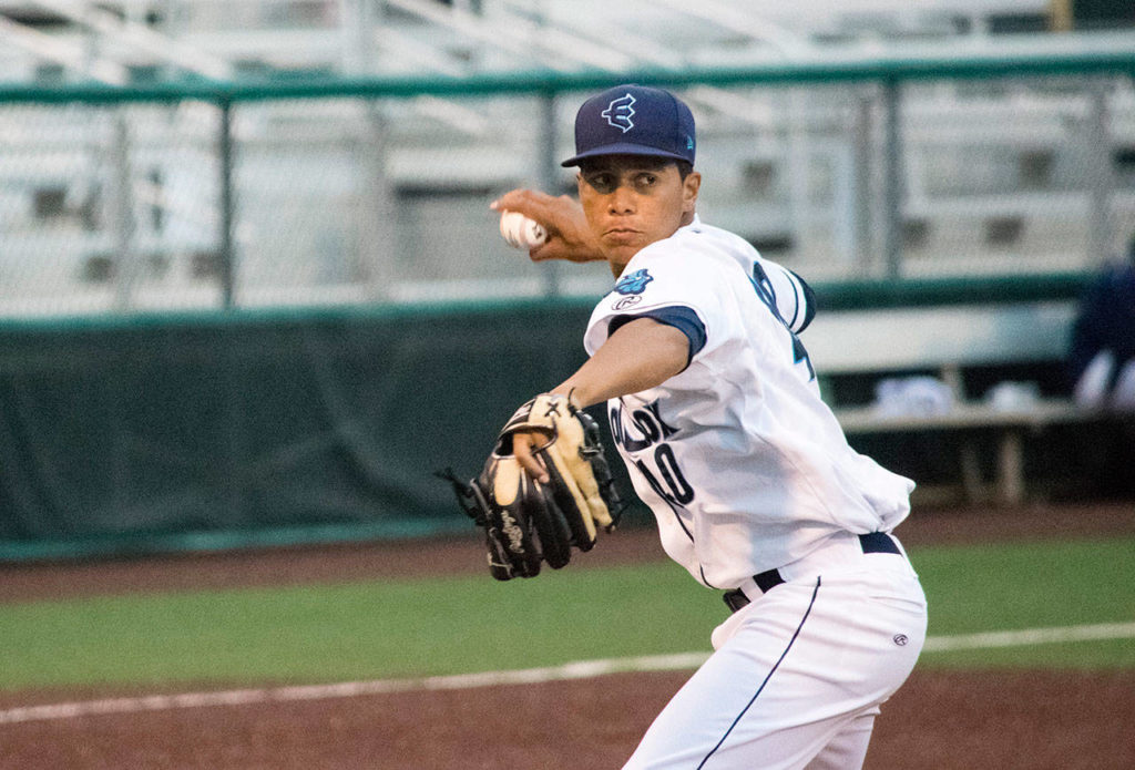 AquaSox pitcher Juan Then throws to first base during a game against the Hawks on July 2, 2019, at Funko Field at Everett Memorial Stadium. (Katie Webber / The Herald)
