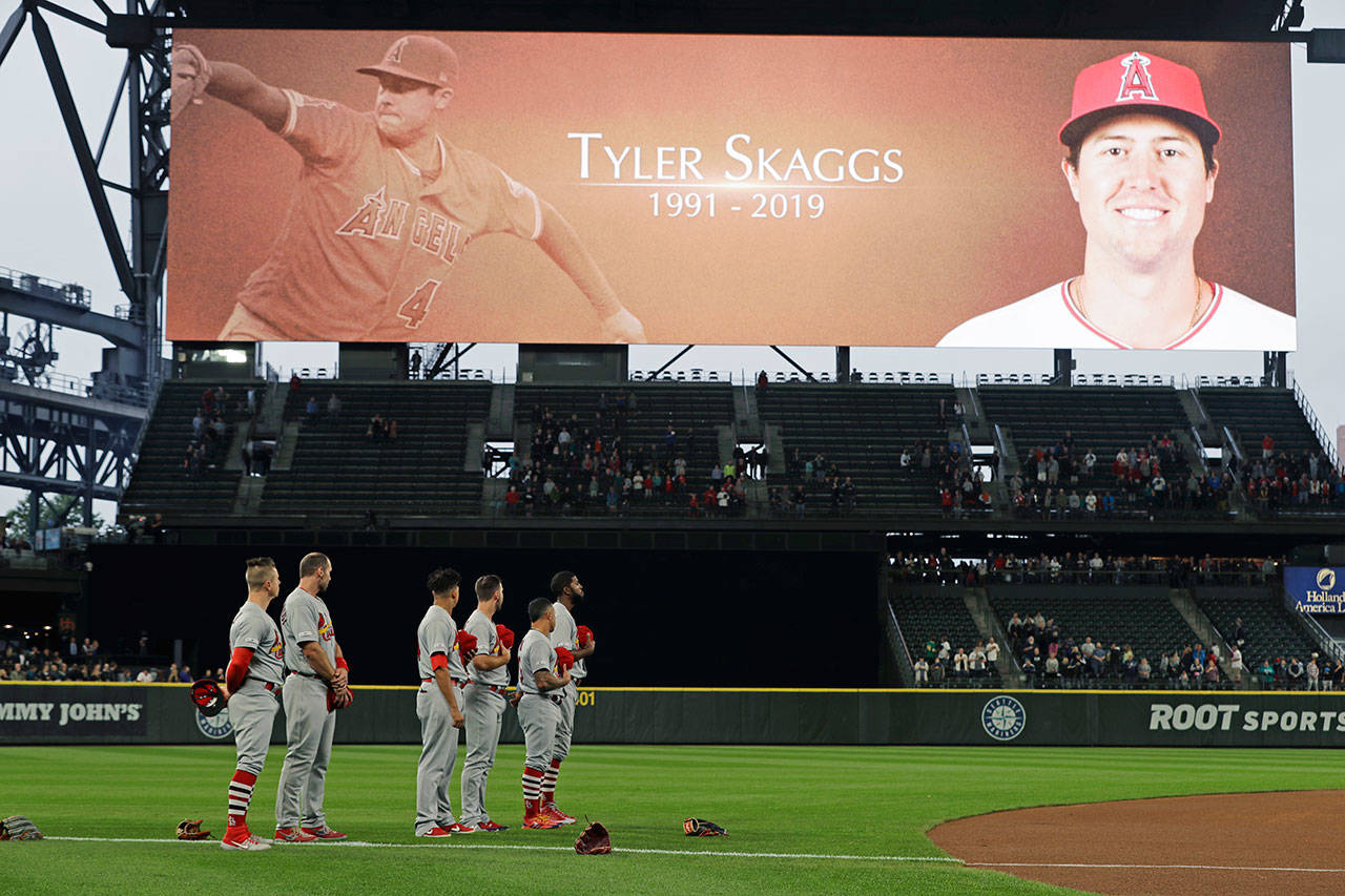 Cardinals players stand on the field at T-Mobile Park in Seattle during a moment of silence in memory of Angels pitcher Tyler Skaggs prior to a game against the Mariners on July 2, 2019. Skaggs was found dead in his hotel room in Texas on July 1, 2019. (AP Photo/Ted S. Warren)