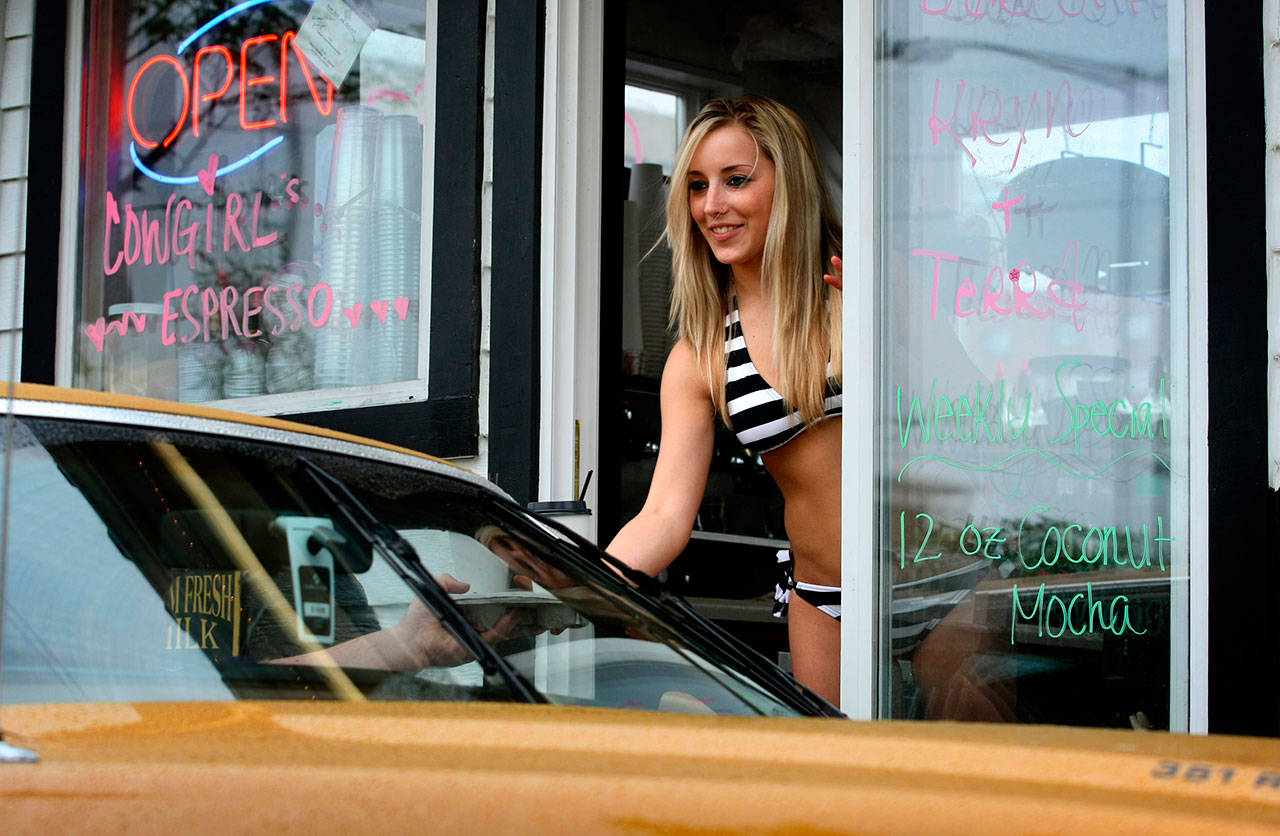 A barista at a “bikini barista” stand serves a customer his drinks at the Cowgirls Espresso stand on Broadway in May 2008. (Kevin Nortz / Herald file photo)