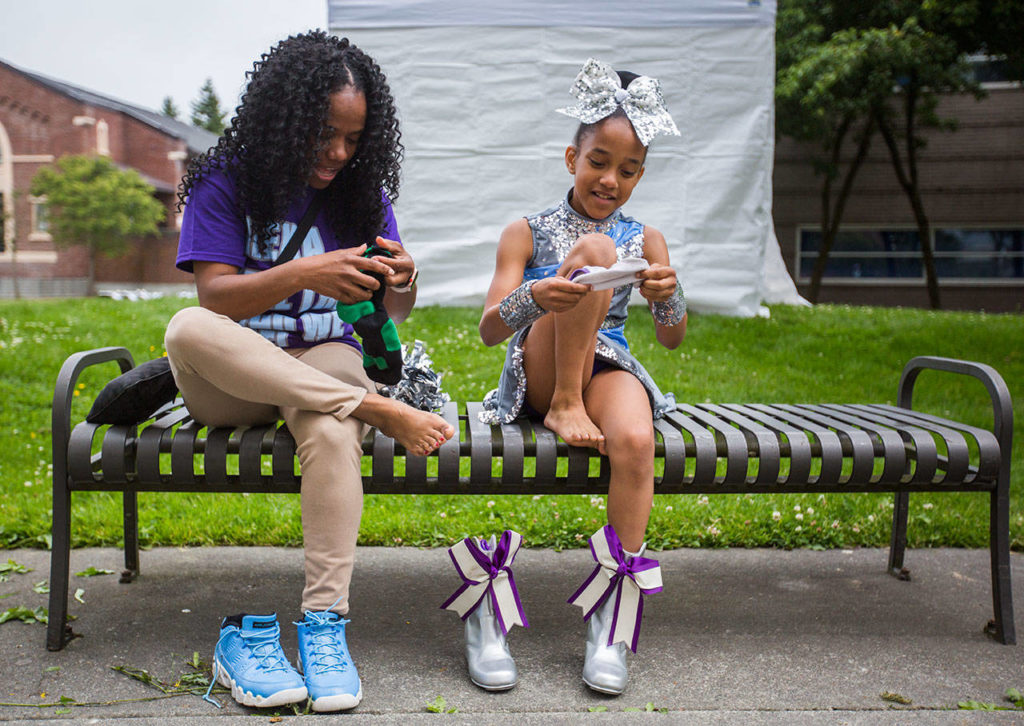 Shameca Orton, left, trades socks with her daughter Jaedyn Orton, 10, so she won’t get blisters from her drill shoes during the Colors of Freedom Fourth of July Parade on Thursday, July 4, 2019 in Everett, Wash. (Olivia Vanni / The Herald)
